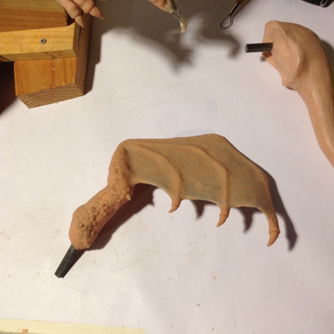 a finished sculpture of the right side dragon wing with wrinkles and scales