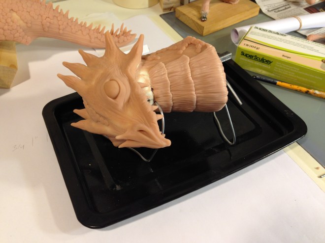 top view of dragon head sculpey ready to be baked on custom wire stand