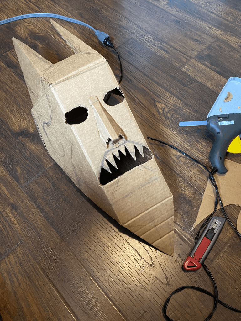 cardboard mask step three with mouth, teeth and horns cut out