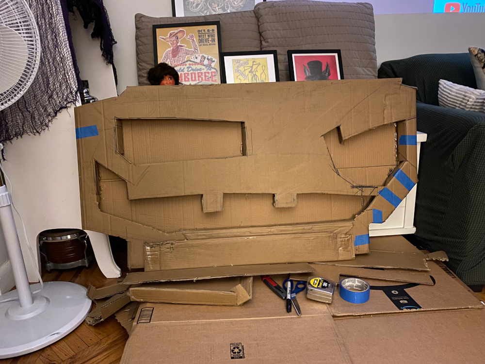 Floory puppet with face shapes cut out from cardboard box